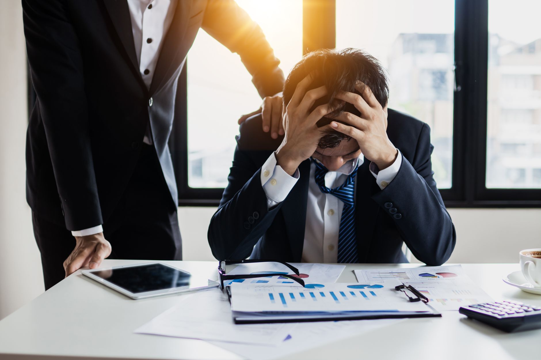 man in black suit jacket feeling stressed